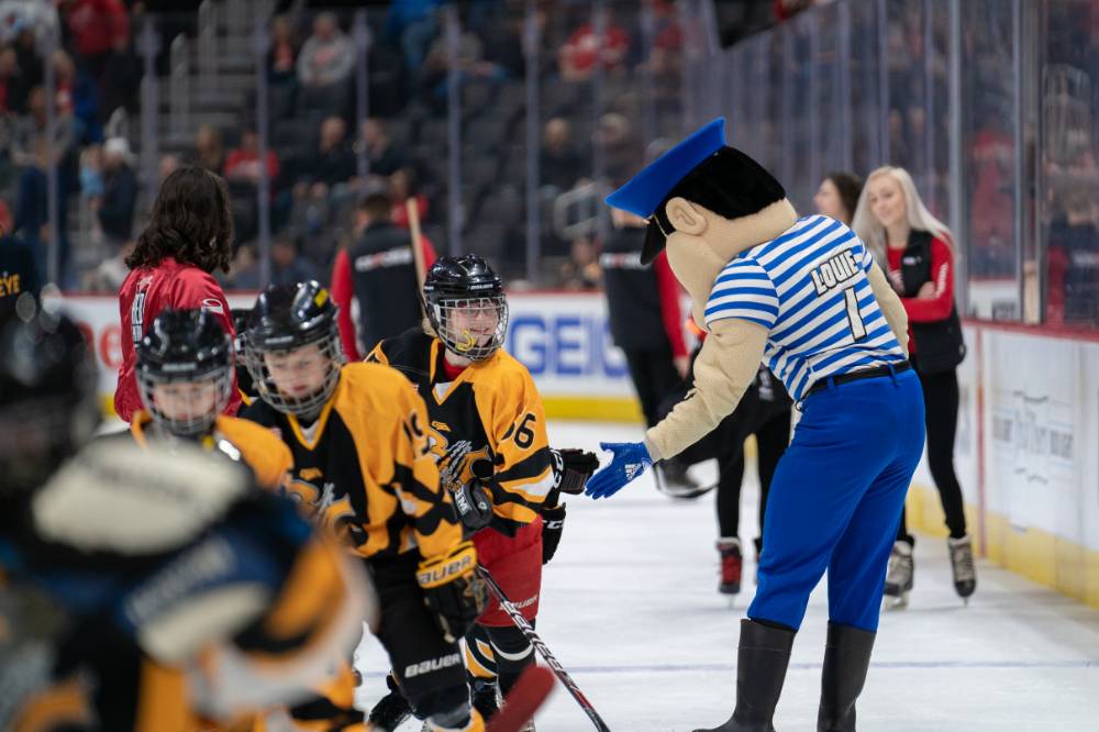 Louie the Laker high fives young hockey players